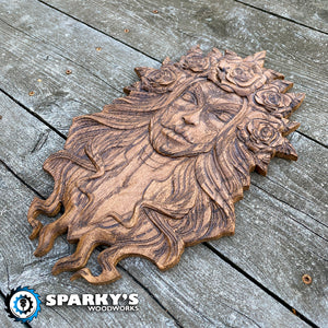 Precision carved and hand stained wooden wall art featuring a woman's face with flowing hair and floral crown, crafted in the USA with fine detail.