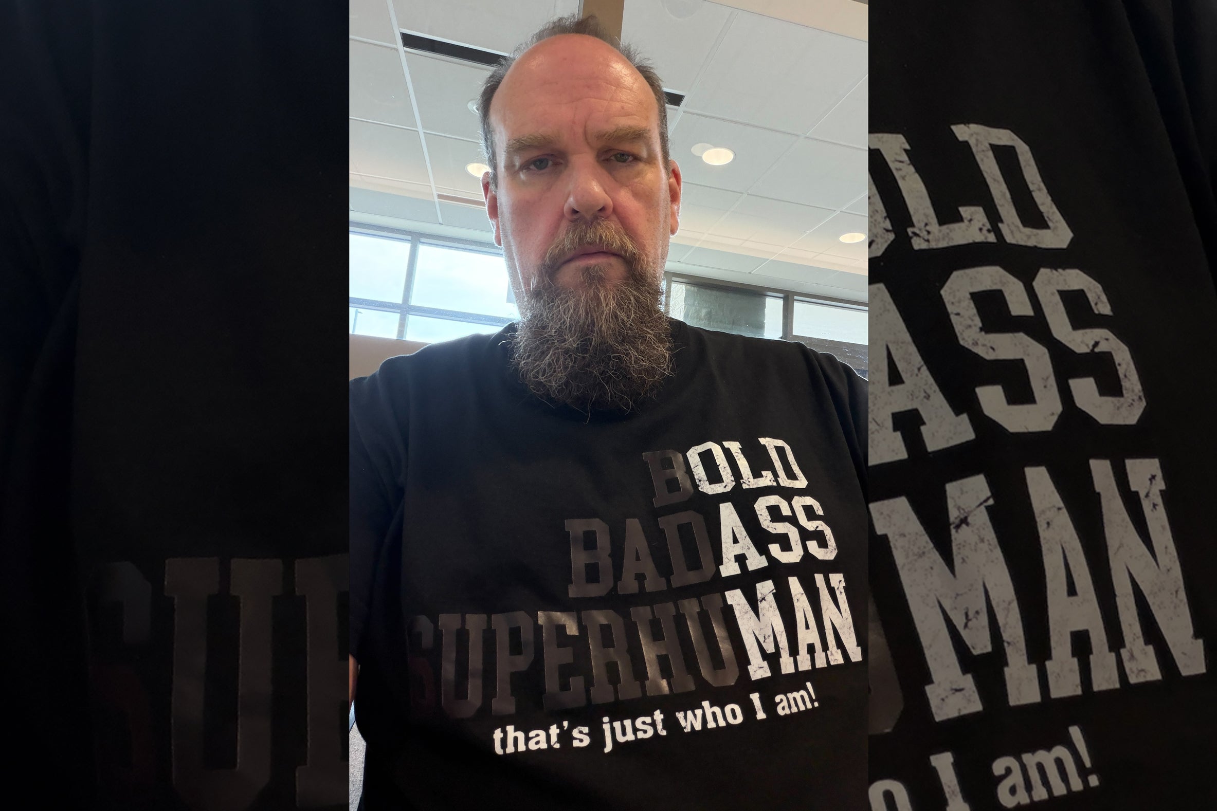 Sparky wearing a black t-shirt reading 'Bold Badass Superhuman — that's just who I am!' taken at the cardiologist's office on Day 2 of his heart health journey.